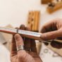 Jeweller checking a silver ring size on a marked ring sizer stick